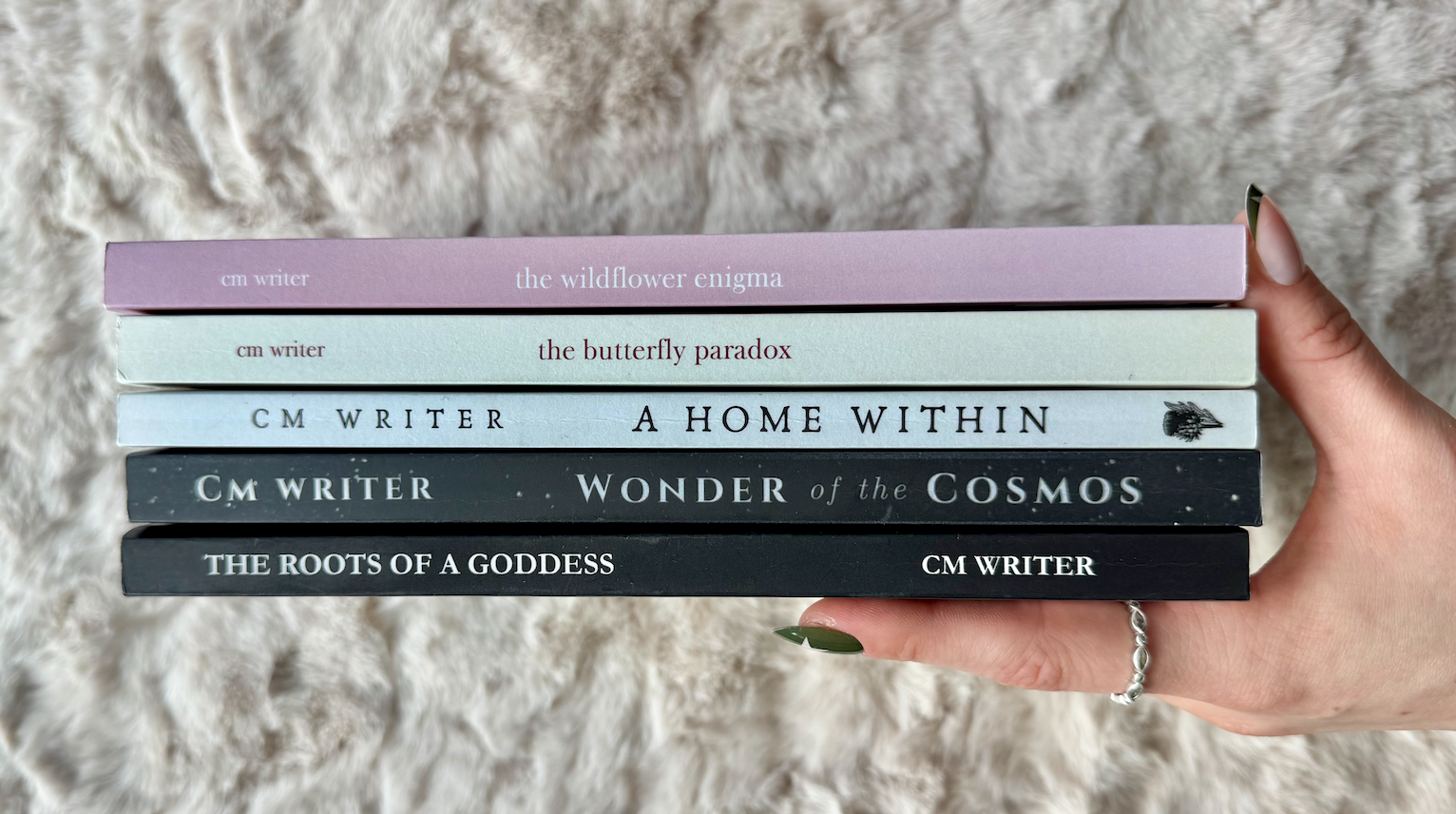 Five CM Writer poetry collections stacked together